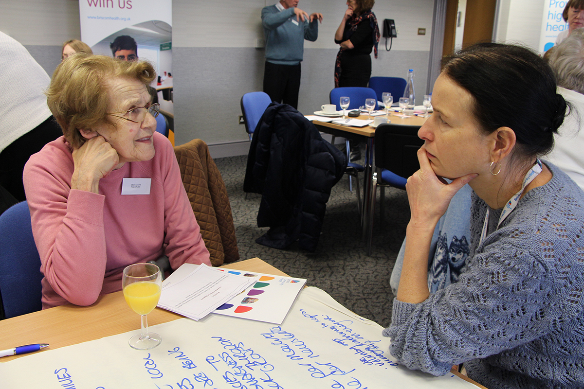 two ladies talking at table
