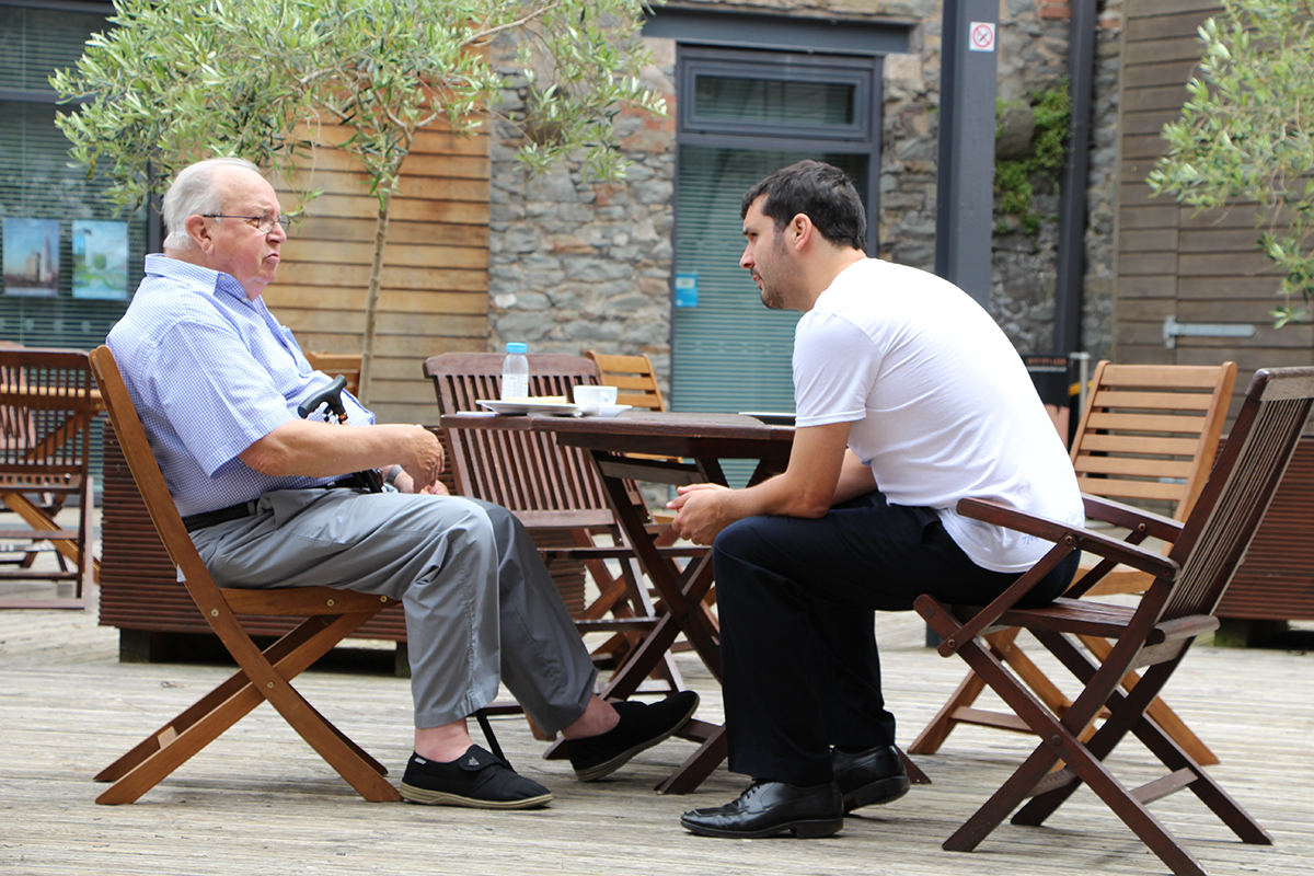 two men talking outside