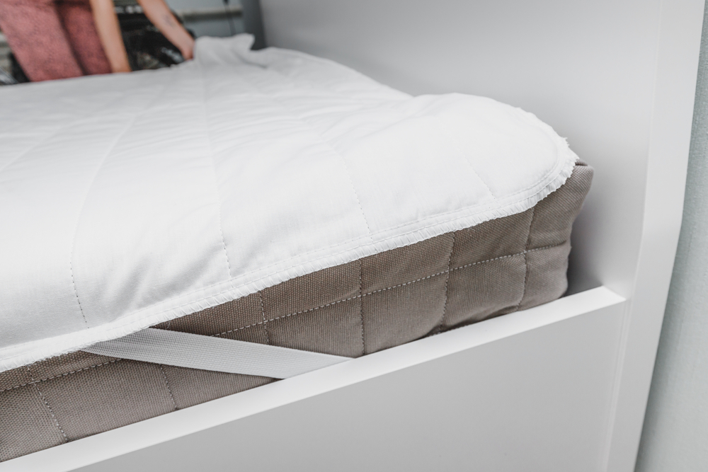 a white piece placed on top of the mattress