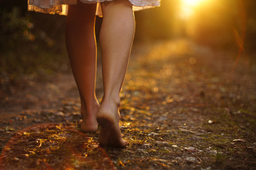 a woman walking barefoot in the forest